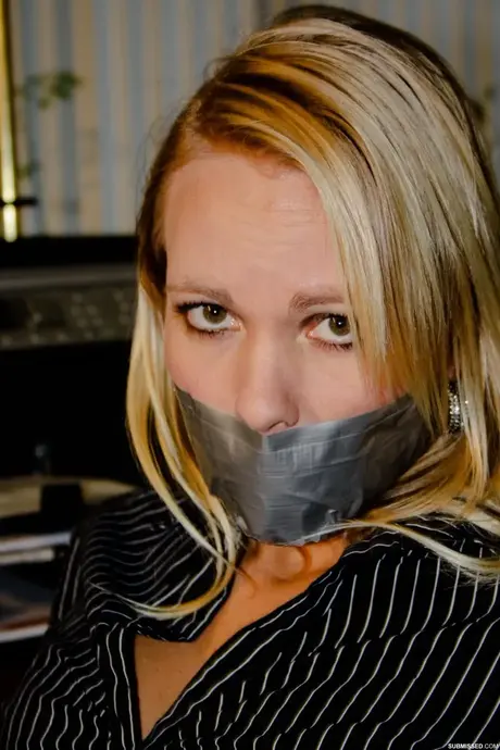 Vollbusige blonde Sekretärin Natalie an einen Stuhl gefesselt, während sie im Büro posiert