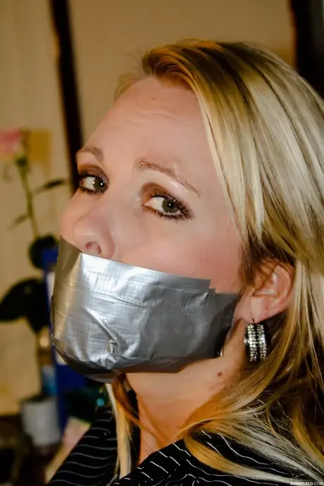 Vollbusige blonde Sekretärin Natalie an einen Stuhl gefesselt, während sie im Büro posiert
