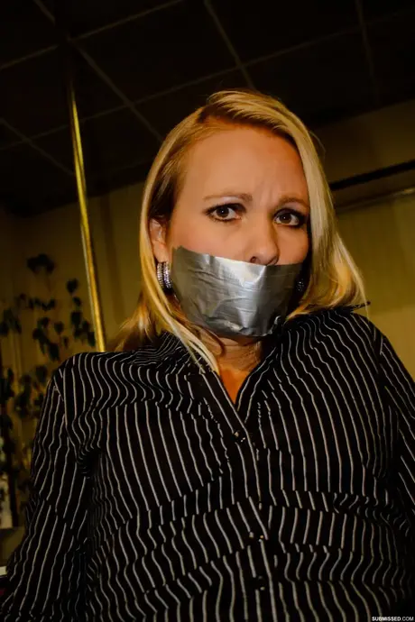 Vollbusige blonde Sekretärin Natalie an einen Stuhl gefesselt, während sie im Büro posiert