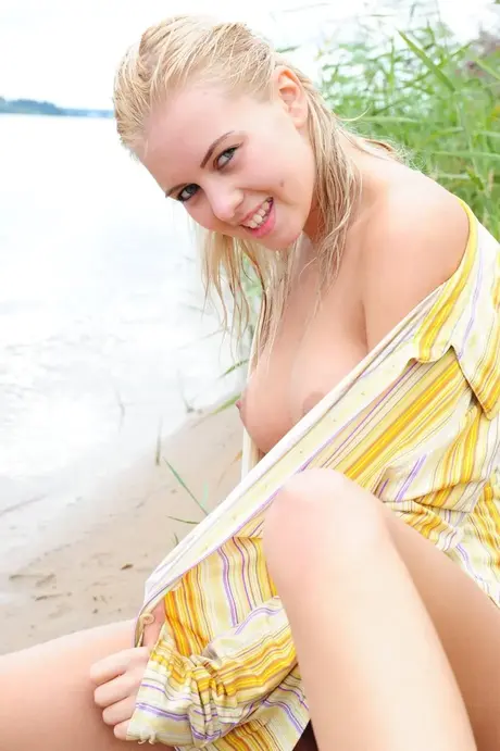 Biustonoszowa blondynka pokazuje swoje nagie ciało sama na plaży