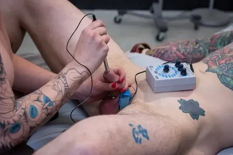 Die üppige Rothaarige Mz Berlin benutzt ein elektrisches Gerät, um den Schwanz ihres Sexsklaven zu sondieren
