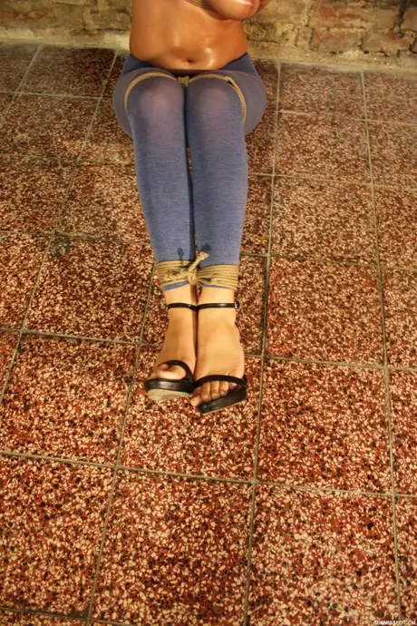 Jenny, a seno nudo e imbavagliata con palla, lotta contro il suo bondage con corde
