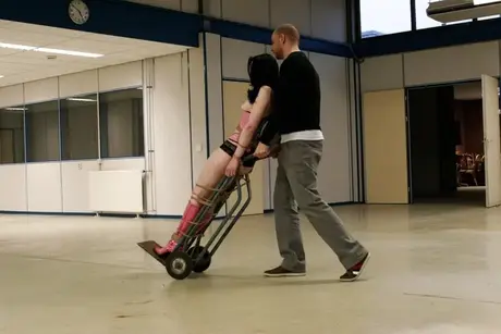 Lilly, kneblet og bundet med reb, rider på en sækkevogn