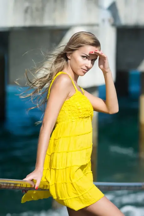 Długowłosa młoda modelka odsłania swoje małe piersi i nagie pośladki na świeżym powietrzu