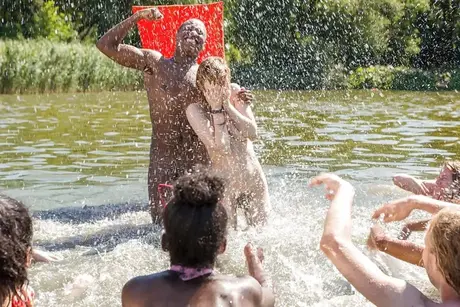 Homens e mulheres europeus amadores nus lutando na praia ao ar livre